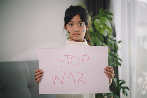 Board No war, Stop war. Little Asian girl. No war with Ukraine. Ukrainian geopolitics globe crisis.
