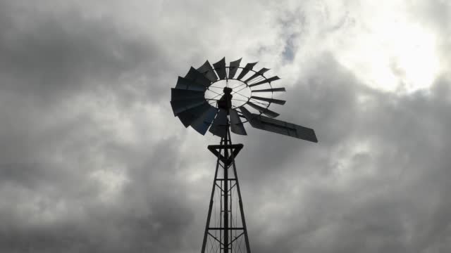 Looking up at a spooky old fashioned windmill on a cloudy day