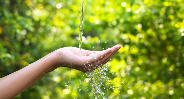 istock Water pouring on hand in morning ligth background 1395241430