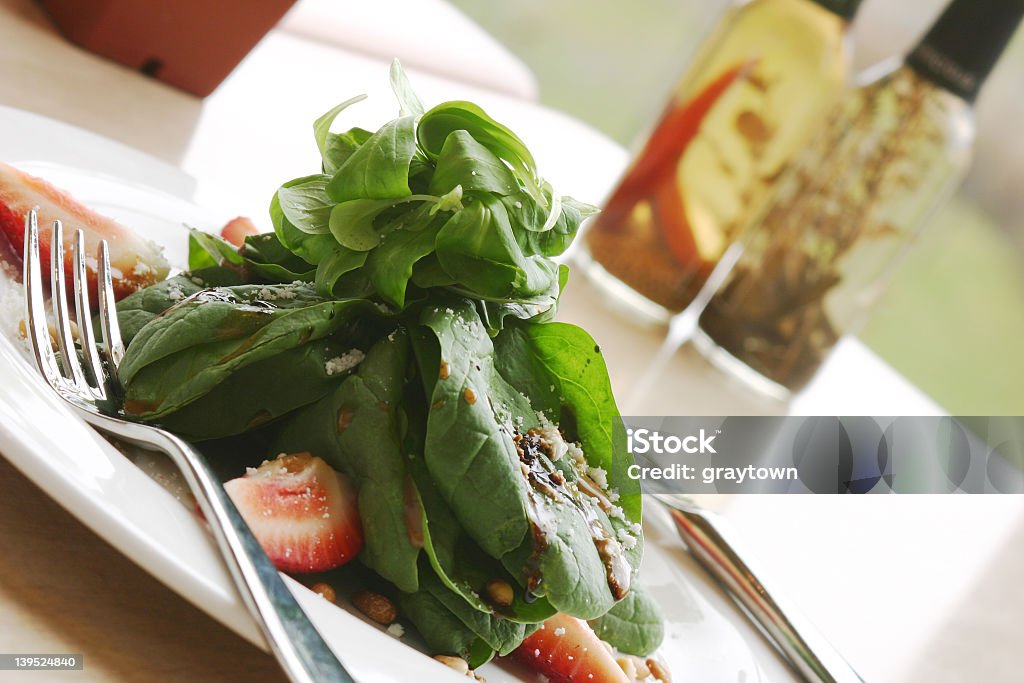 A tasty spinach salad on a white plate Healthy meal of spinach salad. Shallow DOF. Dining Stock Photo