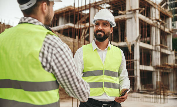 istock Business partners shaking hands on construction site 1395253583