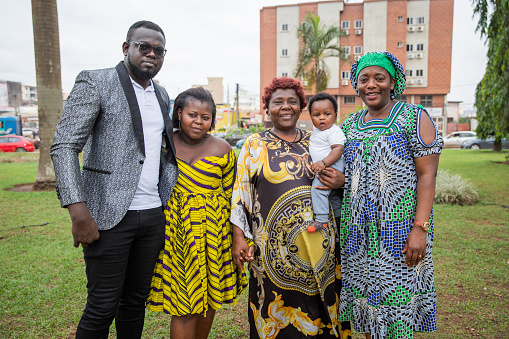 group photo of a multigerational African family, grandmother, parents, son and aunt together smiling and happy