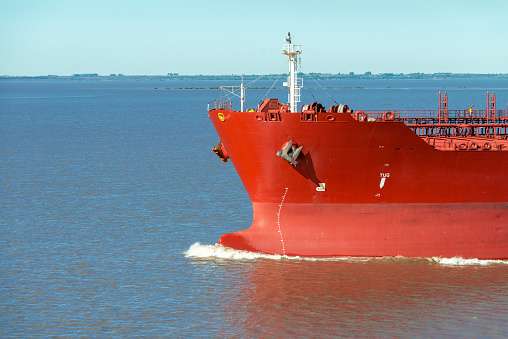 Front view of bow of large tanker cargo ship. Performing cargo export and import operation. Marine background.