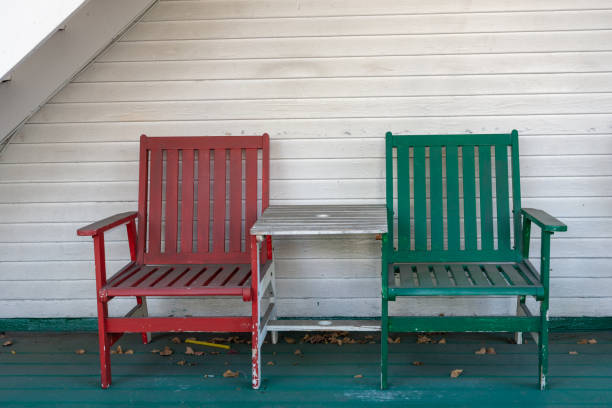 istock Painted wooden chairs with a connecting table on a front porch 1395257467