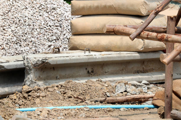 istock Crushed rock for construction and row of raw cement bag stack on a construction site. 1395258961