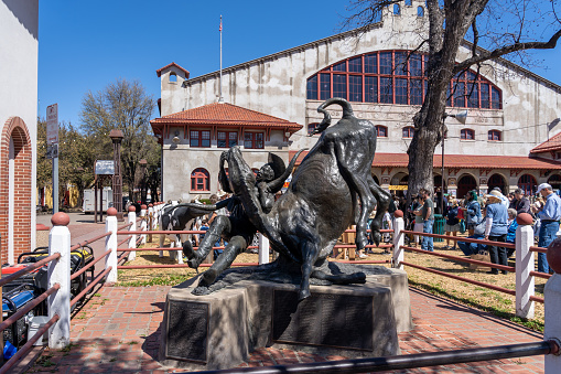 Fort Worth, Texas, USA - March 19, 2022: The statue of Bill Pickett in front of Cowtown Coliseum in the Fort Worth Stockyards, Texas, USA. The Fort Worth Stockyards is a National Historic District.