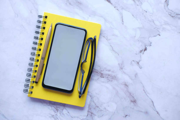 istock top view of smart phone and notepad on tiles background 1395266382