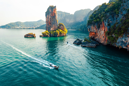 Vistas al mar e islas rocosas con un barco de cola larga. photo