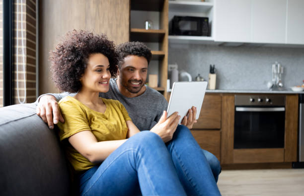 istock Happy couple at home watching a movie on a tablet computer 1395273169
