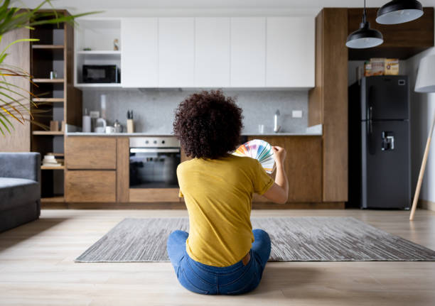 frau zu hause wählt eine farbe, um die wände zu streichen - home addition fotos stock-fotos und bilder