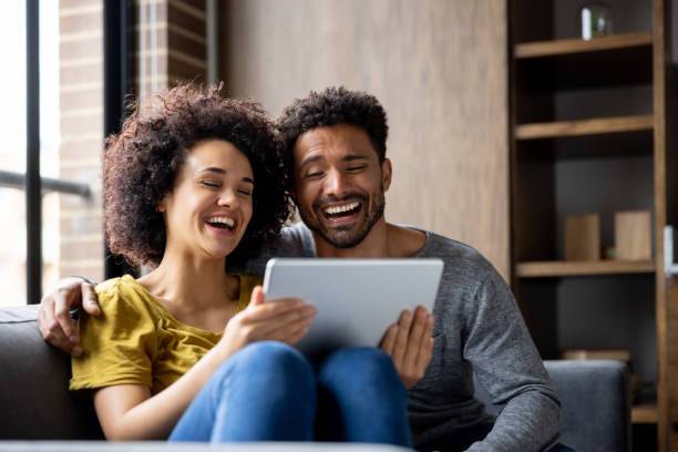 istock Happy couple watching a funny video online on a tablet 1395273181