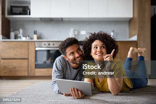 istock Couple thinking about the decoration of their house using an app on a tablet 1395273214