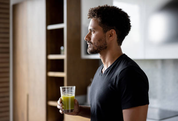 istock Healthy man drinking a green detox smoothie 1395273253