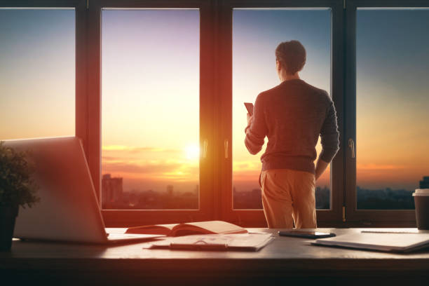 istock Man is standing near window in office 1395273954