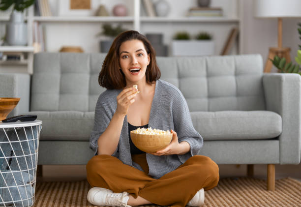 woman watching tv - lanche da tarde imagens e fotografias de stock