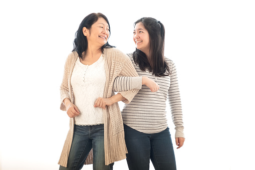 Chinese mother and multiracial daughter portrait on white background.