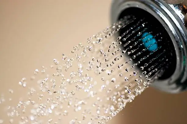 Macro shot of water flowing from showerhead