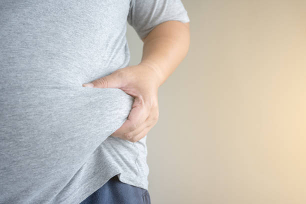 istock An obesity carrying his chubby belly front view. 1395279847