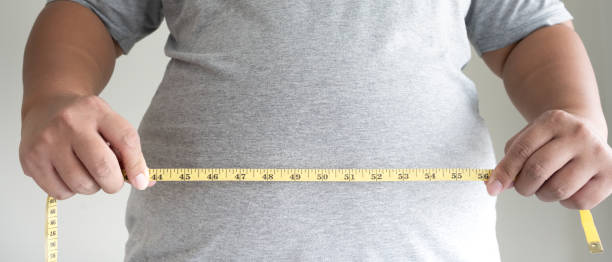 istock An obesity using measuring tape to show the real size. 1395279876