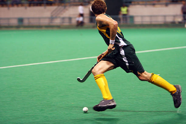 Male field hockey player running with ball Hockey player in action. field hockey stock pictures, royalty-free photos & images