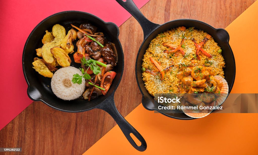 PERUVIAN FOOD: Rice with seafood and Lomo saltado, Typical food of Peruvian cuisine. Selective focus PERUVIAN FOOD: Rice with seafood and Lomo saltado, Typical food of Peruvian cuisine. Beef tenderloin with purple onion, yellow chili, tomatoes, served in pan Food Stock Photo