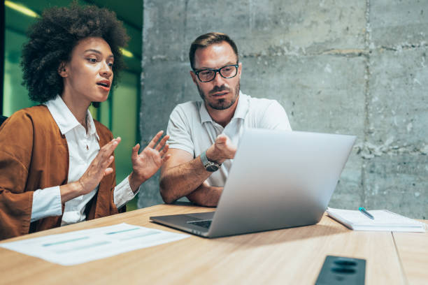istock Two business people working together in office 1395282860