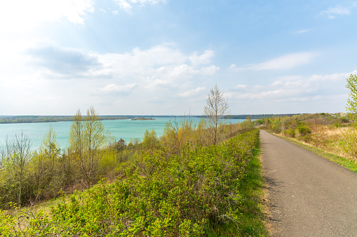 Scenic bike path down to the Markkleeberger lake near Leipzig in early spring