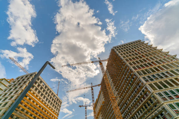istock Construction cranes near the facade of a house under construction. 1395288972