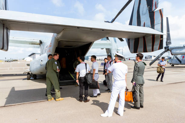 soldado americano falando com viajantes perto de um avião no singapore airshow. - v22 - fotografias e filmes do acervo