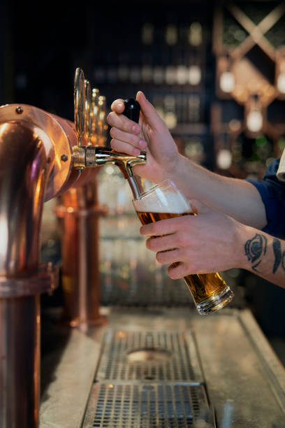 istock Close up of bartender serving beer at bar 1395290938