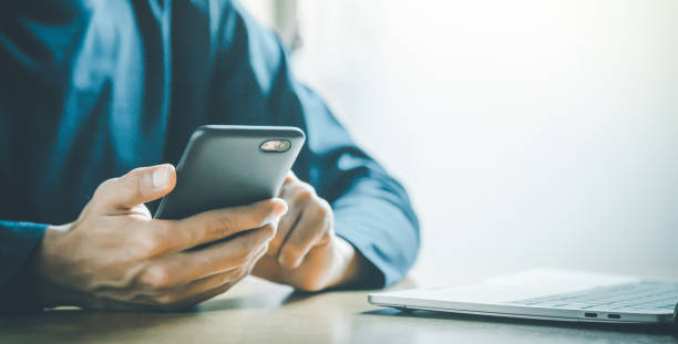 istock Man holding and using smartphone for sms messages, hipster man typing touchscreen cell phone in the cafe. business, lifestyle, technology and Social media network concept. 1395291251