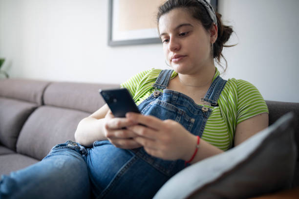 istock Pregnant woman using smart phone at home. 1395291832