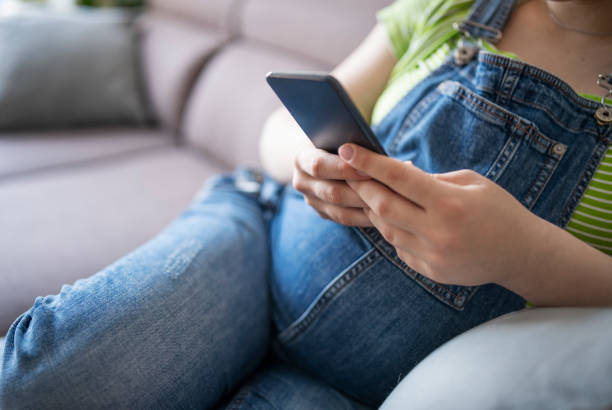 istock Expecting woman relaxing on sofa and using smartphone. 1395291836