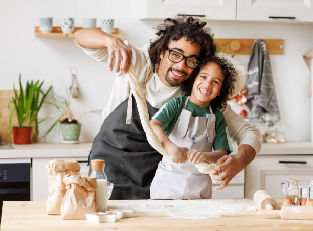 istock Happy black father and son preparing dough together 1395292187