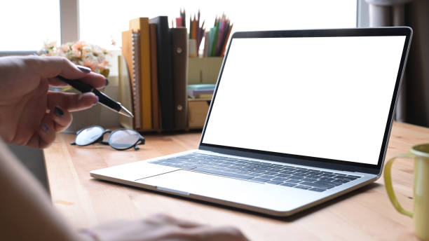 istock Cropped image of female freelancer holding pencil and using laptop computer. 1395293326