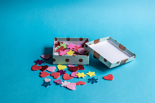 Gift box with colorful hearts and stars on a blue background.