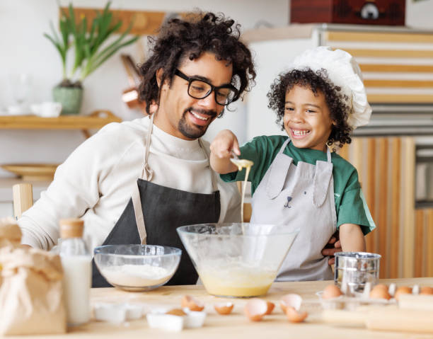istock Black man and son cooking together in kitchen 1395295190