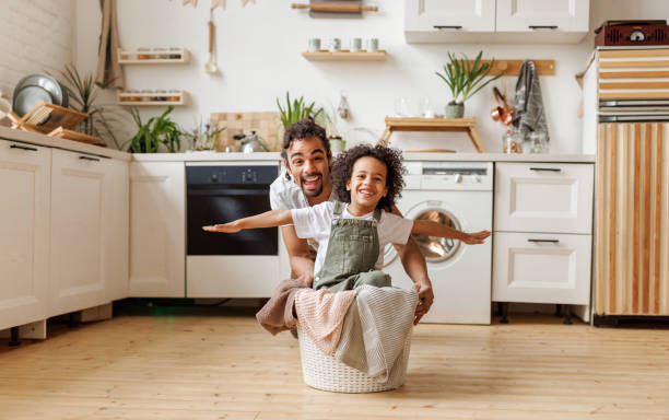 istock Happy father playing with son while washing in the home laundry in kitchen 1395295962