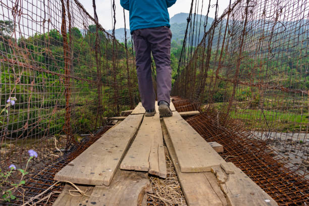 istock man walking at vintage iron suspension bridge from low angle 1395296179