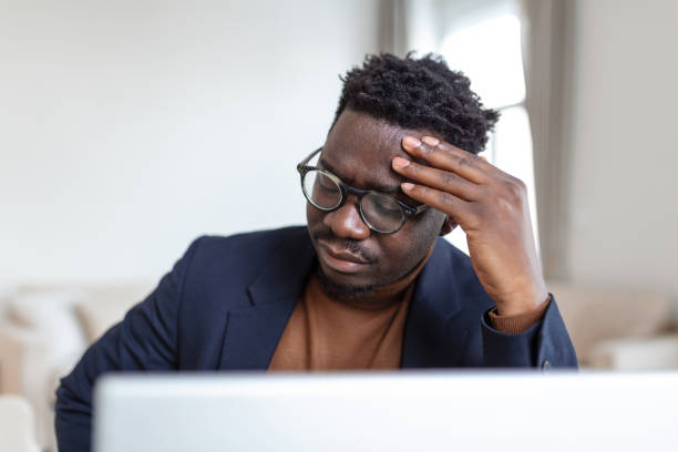 istock Stressed tired African American man touching temples, suffering from headache after long hours work, overworked overwhelmed businessman sitting at desk, feeling unwell 1395296239