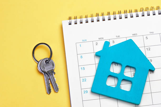 istock Blue house with calendar and keys on yellow background 1395297404