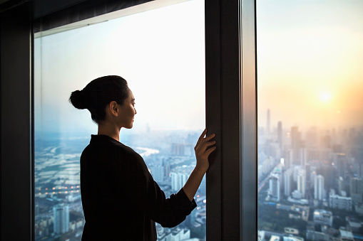 Chinese woman proudly looking at real estate industry progress in downtown city, Shenzhen, China