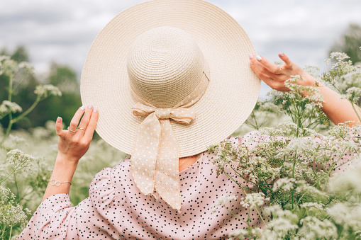 Pink women`s straw hat with pattern at outdoors shop.