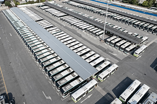 Aerial view of bus depot with electric buses charging battery