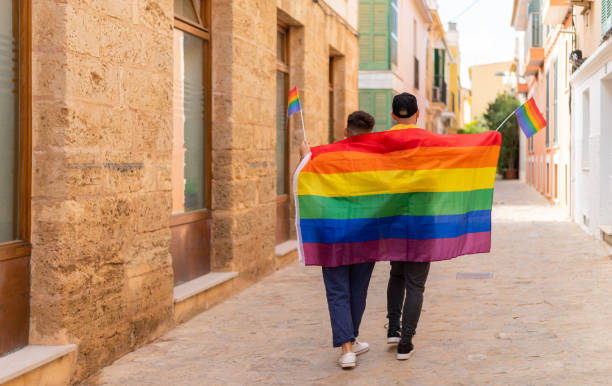 uomo irriconoscibile con bandiera lgbt per strada - homosexual gay man symbol homosexual couple foto e immagini stock