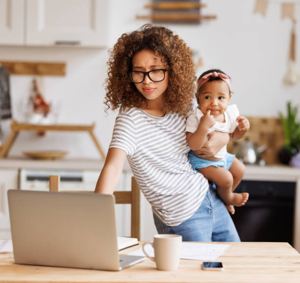 istock Multitasking african american self-employed mother working with baby from home on maternity leave 1395299842