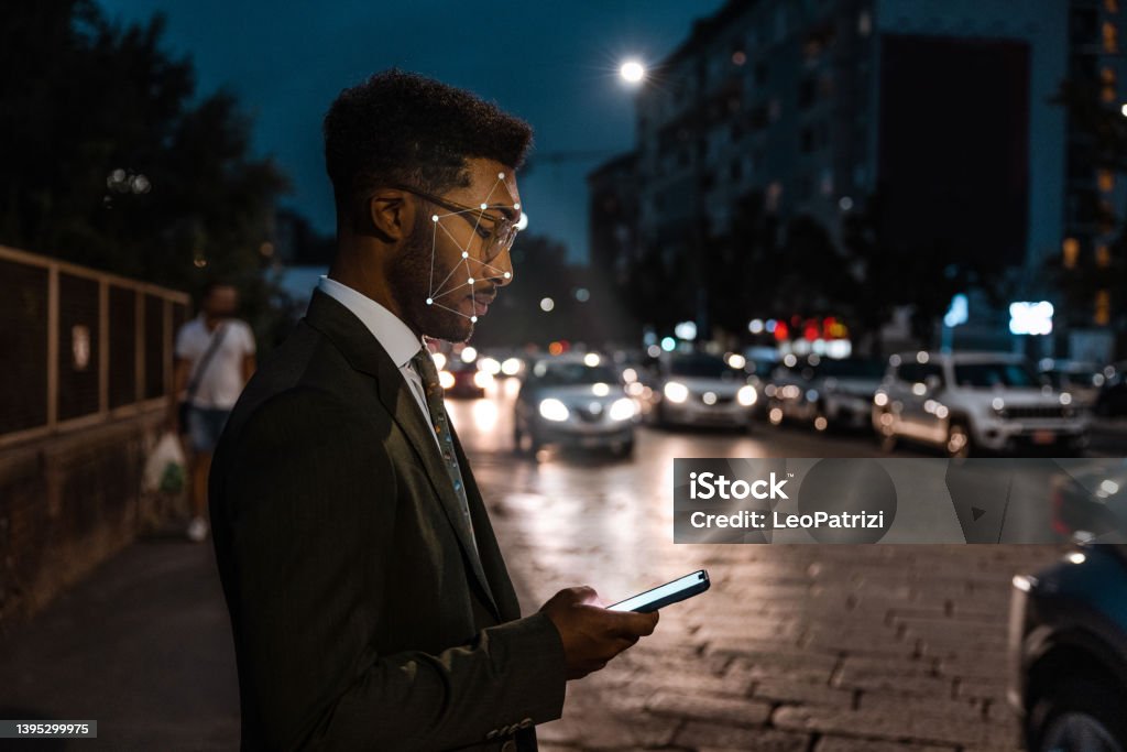 Biometric face recognition technology Man using face recognition technology in the city street. Facial Recognition Technology Stock Photo