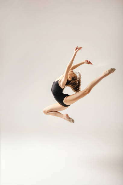 istock Girl gymnast performs a jump to the top. 1395302084
