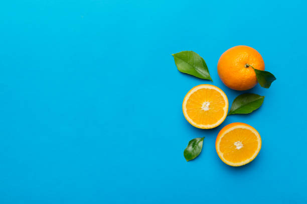 istock fresh Fruit orange slices on colored background. Top view. Copy Space. creative summer concept. Half of citrus in minimal flat lay with copy space 1395303899