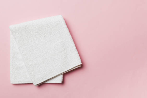 istock Top view of white towels with copy space on colored background 1395303976